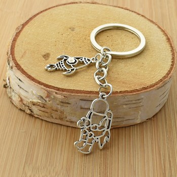 Silver origami-style astronaut and rocket key ring