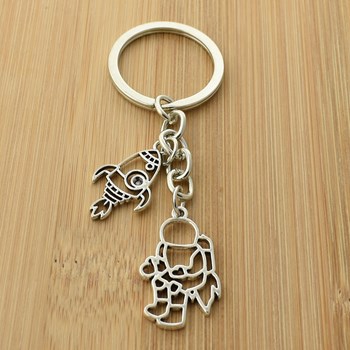 Silver origami-style astronaut and rocket key ring