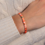 Bracelet élastiques perles japonaises MIYUKI en verre émaillé ton orange blanc et doré 17cm - vue porté 1