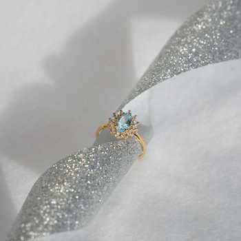 Bague or 375 2 tons fleur topaze bleue traitée ovale et zirconias
