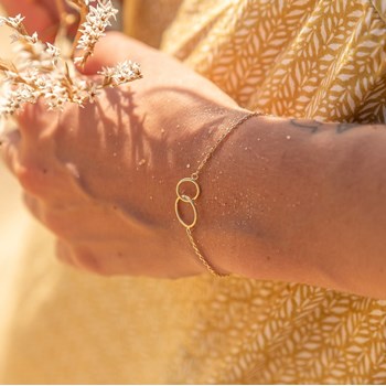 Vergulde armband met 2 in elkaar gevlochten cirkelringen