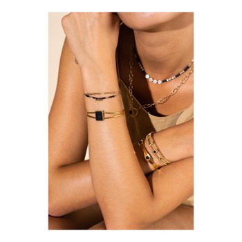 Stijve verstelbare verguld stalen armband versierd met een natuurlijke zwarte steen