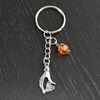 Porte-clés main qui tient un coeur love argentée et perle à facettes orange - vue V4