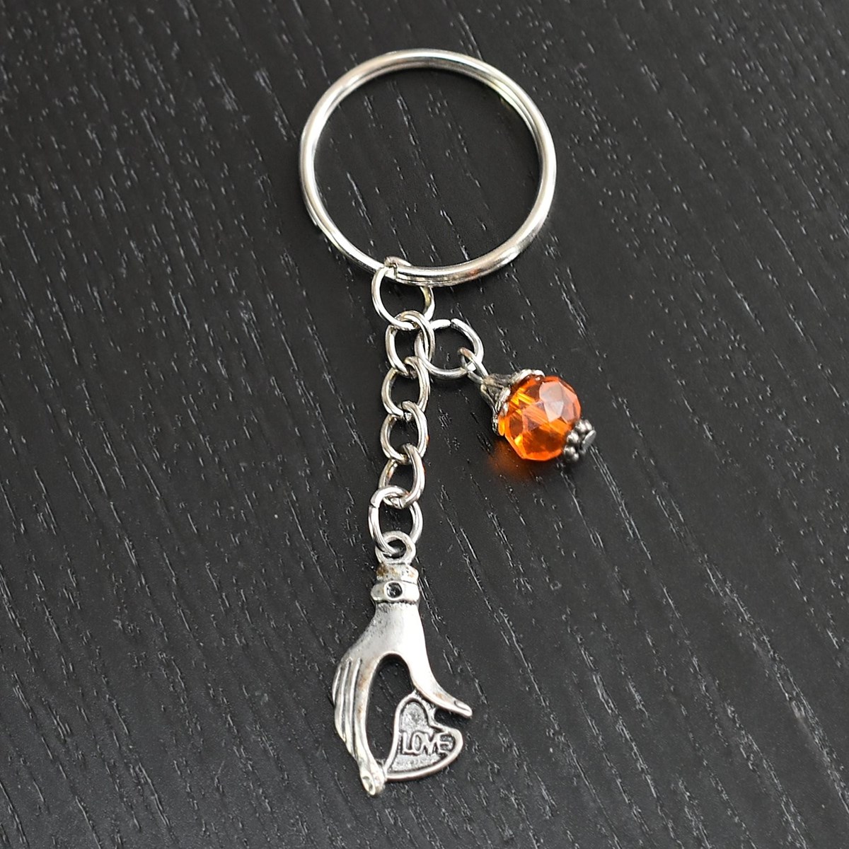 Porte-clés main qui tient un coeur love argentée et perle à facettes orange - vue 4