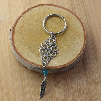 Porte-clés losange filigrane perle à facette bleue et plume pendante argenté