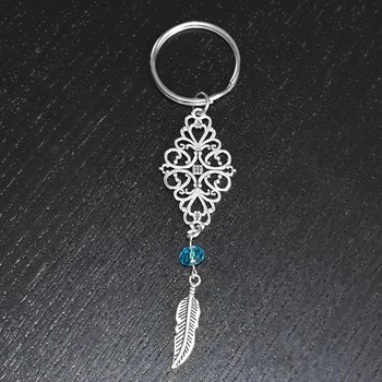 Porte-clés losange filigrane perle à facette bleue et plume pendante argenté