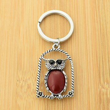 Rode uil sleutelhanger op zijn zitstok met bloemen en zilveren strass ogen