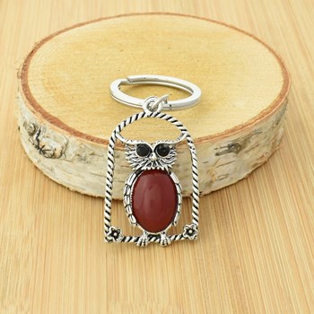 Rode uil sleutelhanger op zijn zitstok met bloemen en zilveren strass ogen