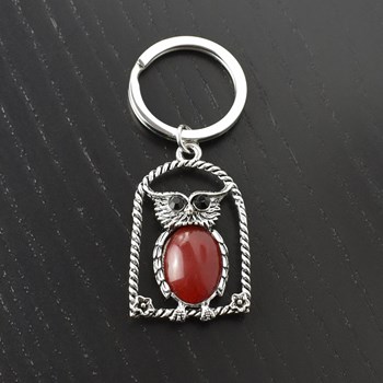 Rode uil sleutelhanger op zijn zitstok met bloemen en zilveren strass ogen