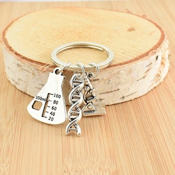 Kleine wetenschappelijke sleutelhanger, microscoop, DNA-streng en zilveren gegradueerde erlenmeyer